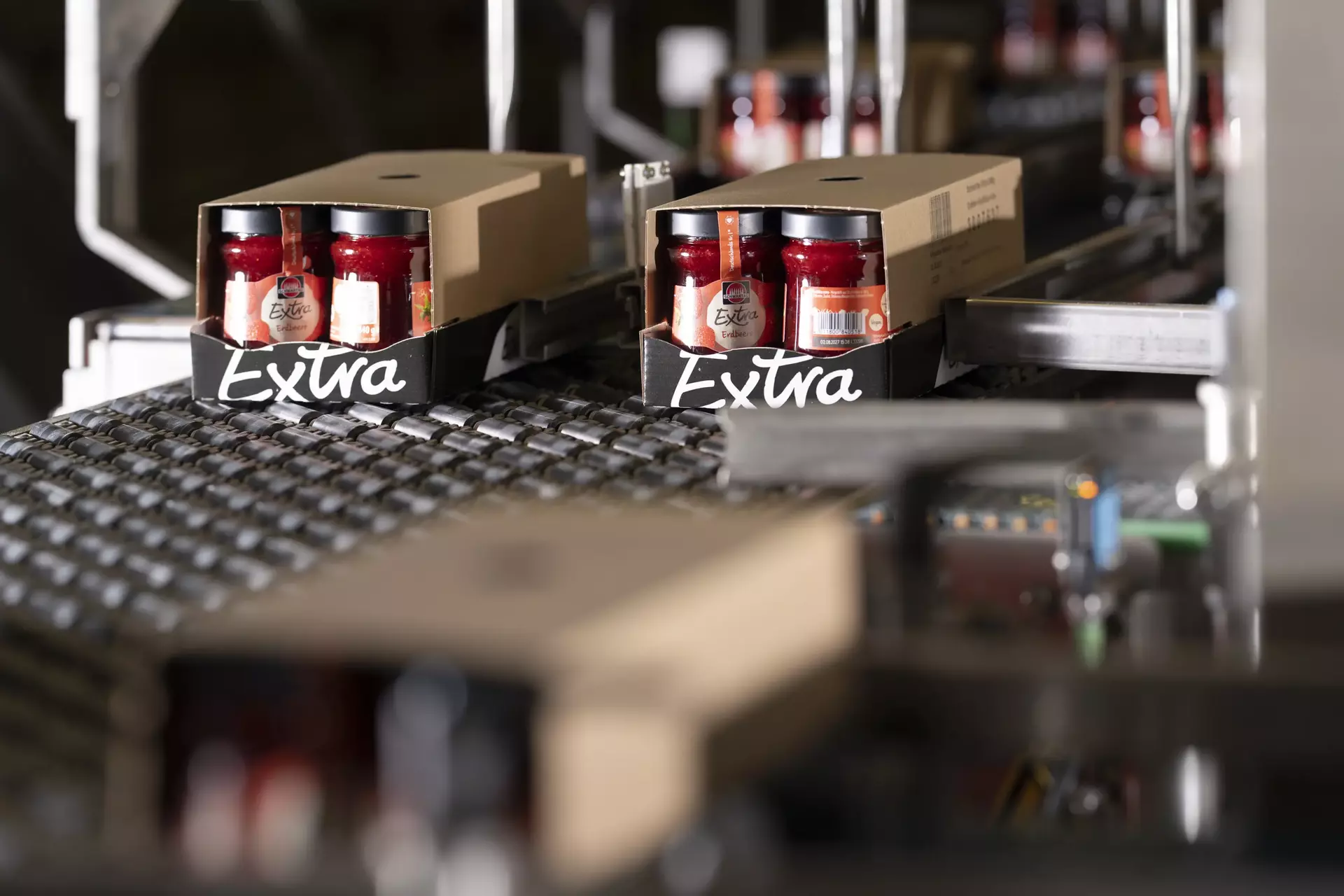 Erdbeer-Konfitürengläser im Verpackungstray auf einem Förderband