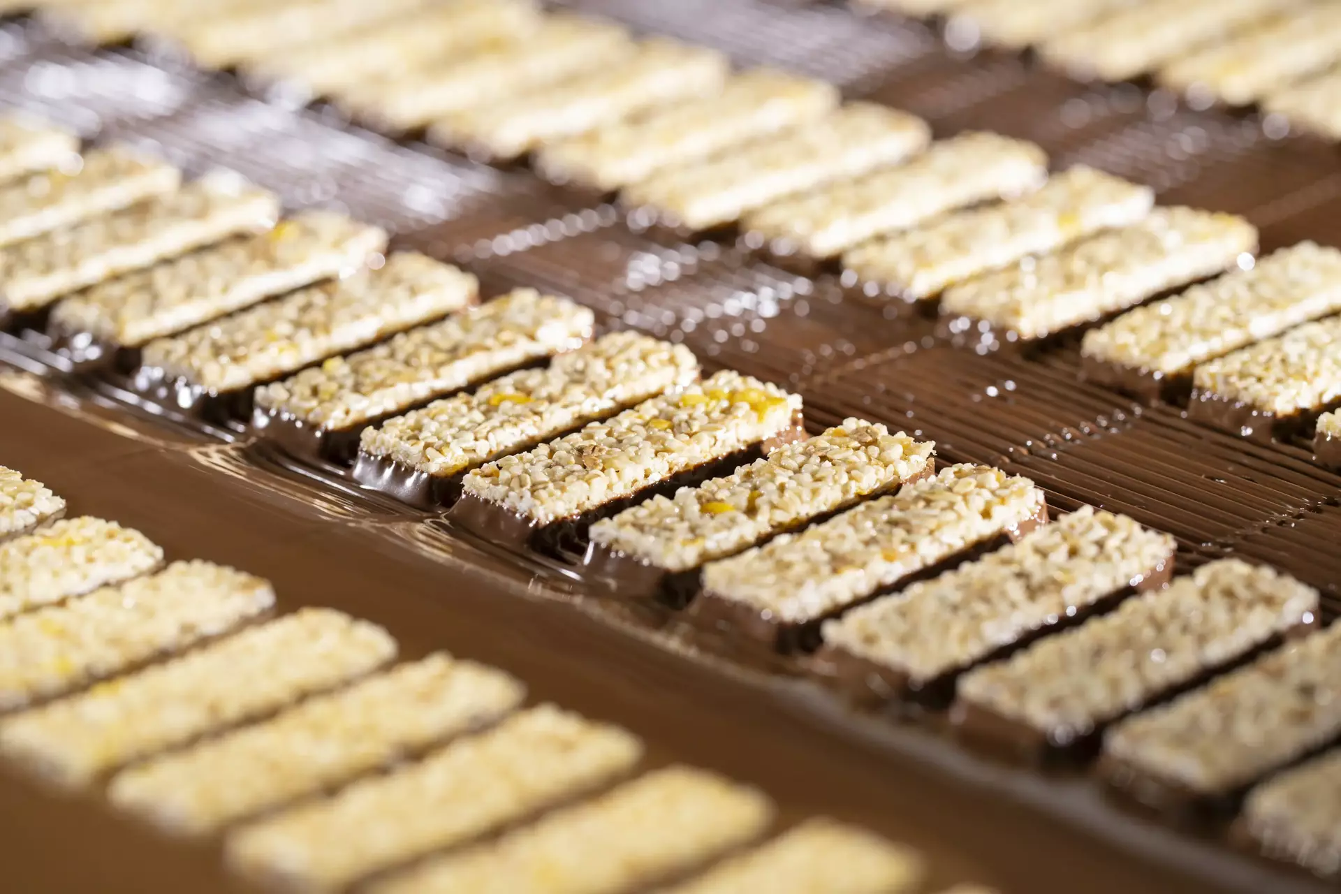 Corny Riegel fahren durchs Schoko-Bad auf dem Förderband