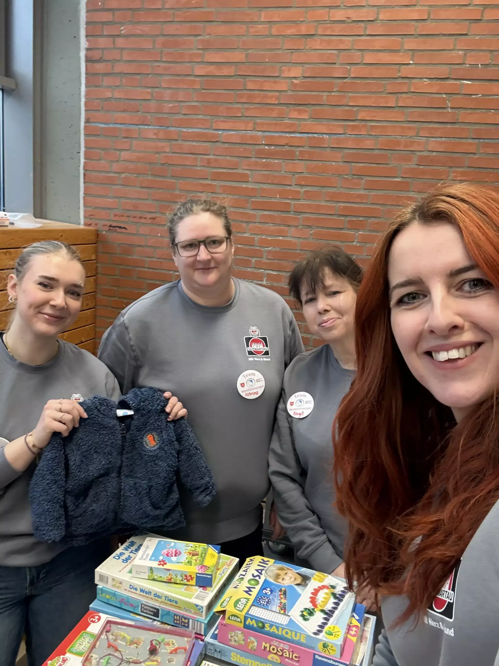 Ein Selfie von vier Kolleginnen am Stand der Kleiderkammer.