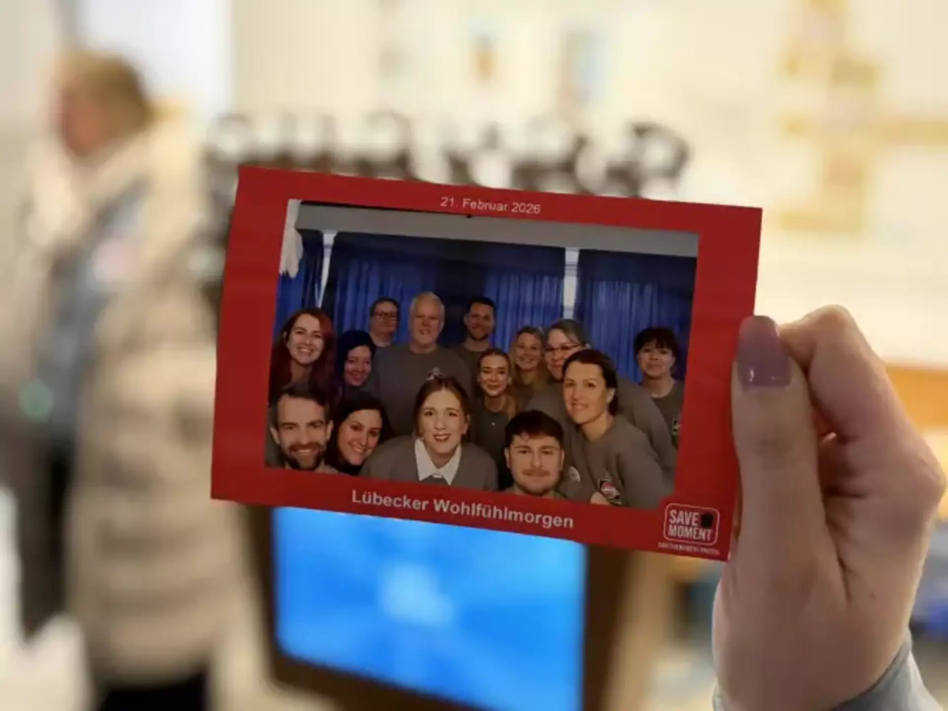 Eine Hand hält das ausgedruckte Gruppenfoto aus einer Fotobox.