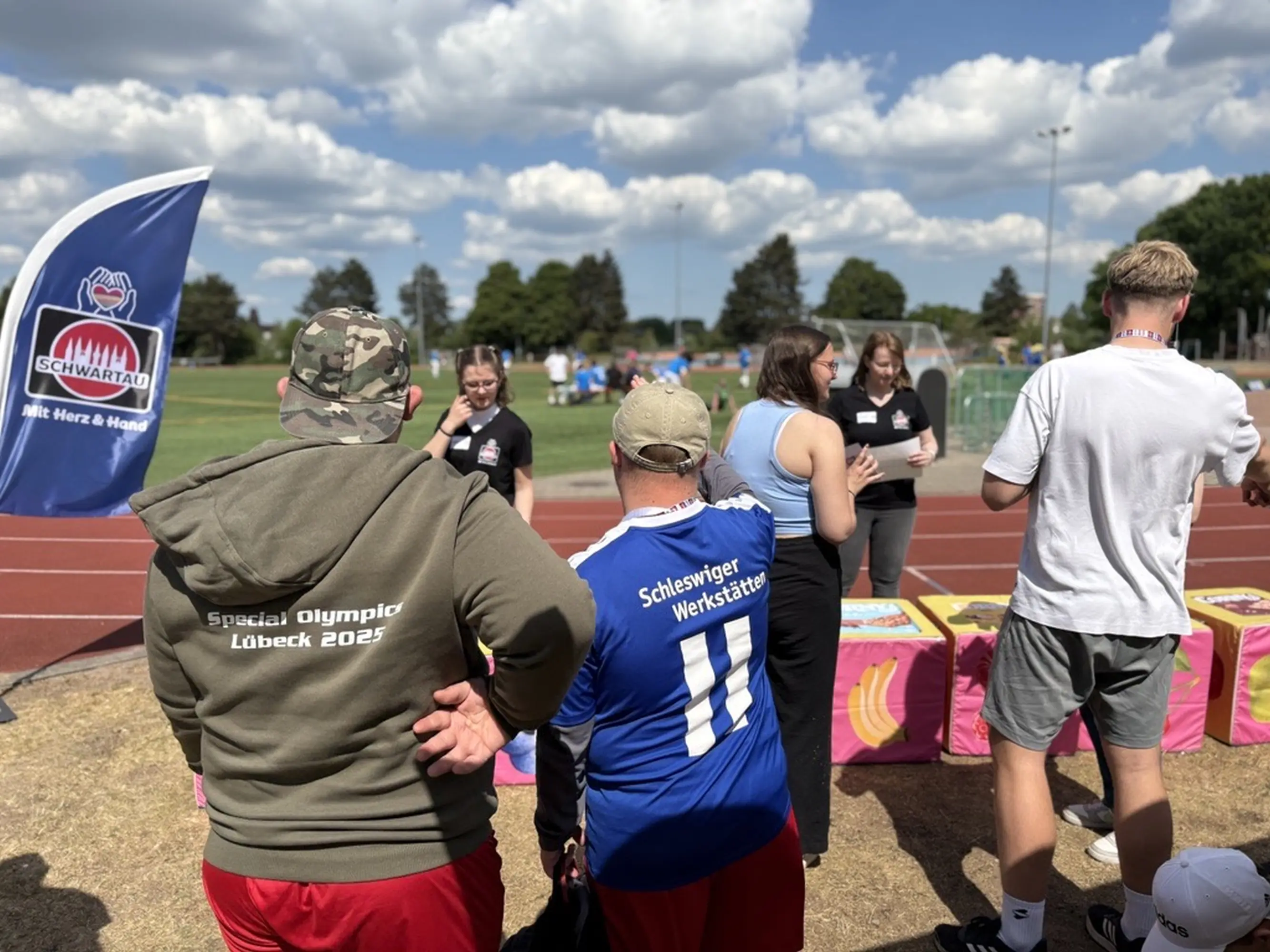 Aktionsfläche auf einem Sportplatz, vorne sieht man zwei Personen der Schleswiger Werkstätten.